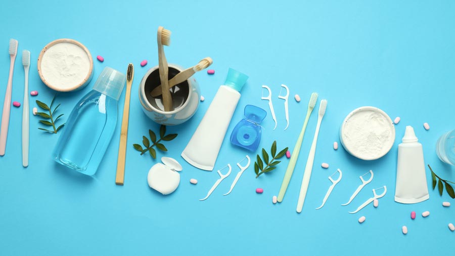 A collection of toothbrushes and toothpaste on a blue background, promoting oral hygiene