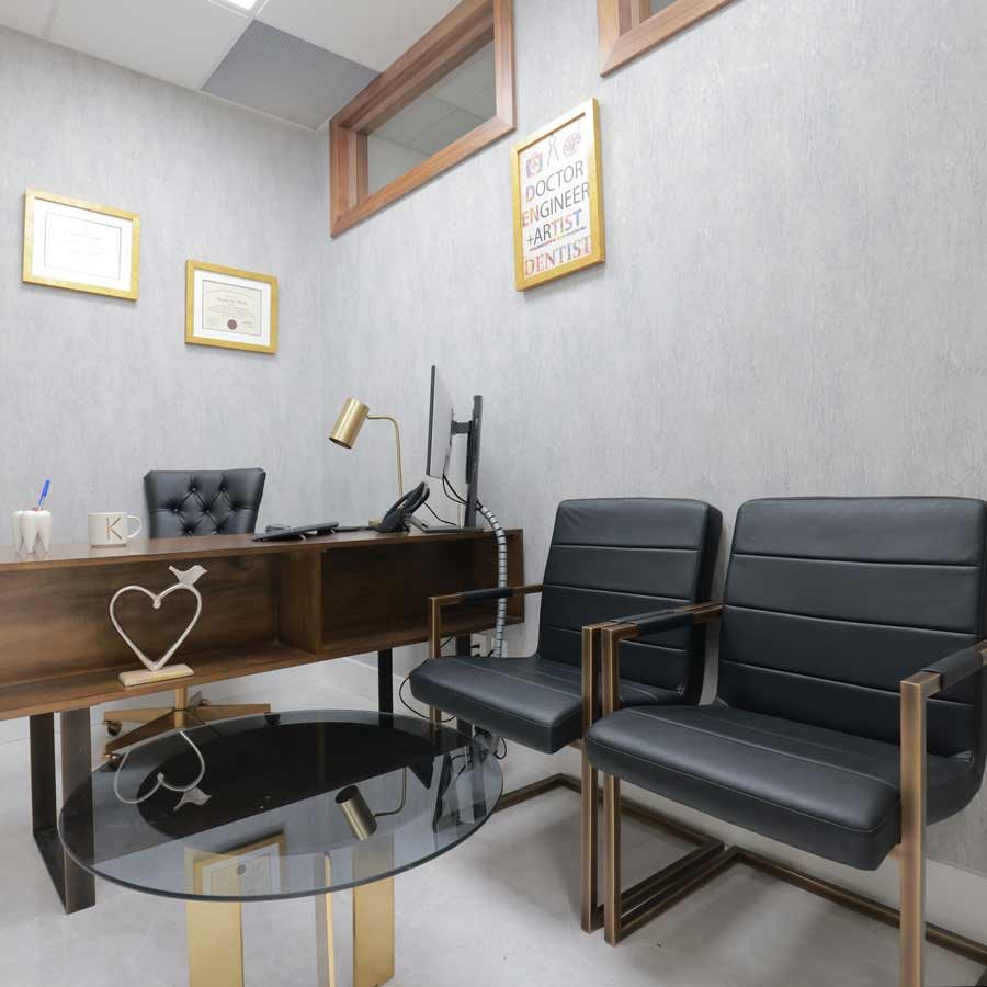 Modern dental office with black chairs and desk. Contact us to book an appointment