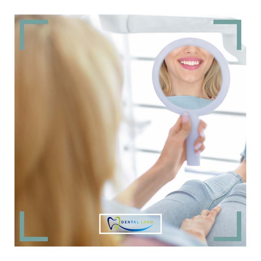 A woman examining her teeth in a mirror, focusing on Teeth Whitening