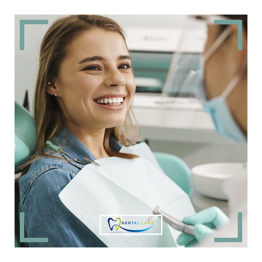 A woman with a bright smile sitting comfortably in a dentist chair, receiving dental treatment