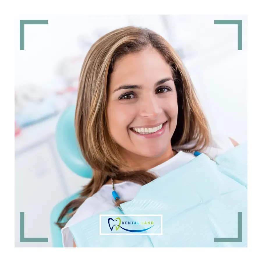A woman with a bright smile sits comfortably in a dentist chair, displaying confidence and ease