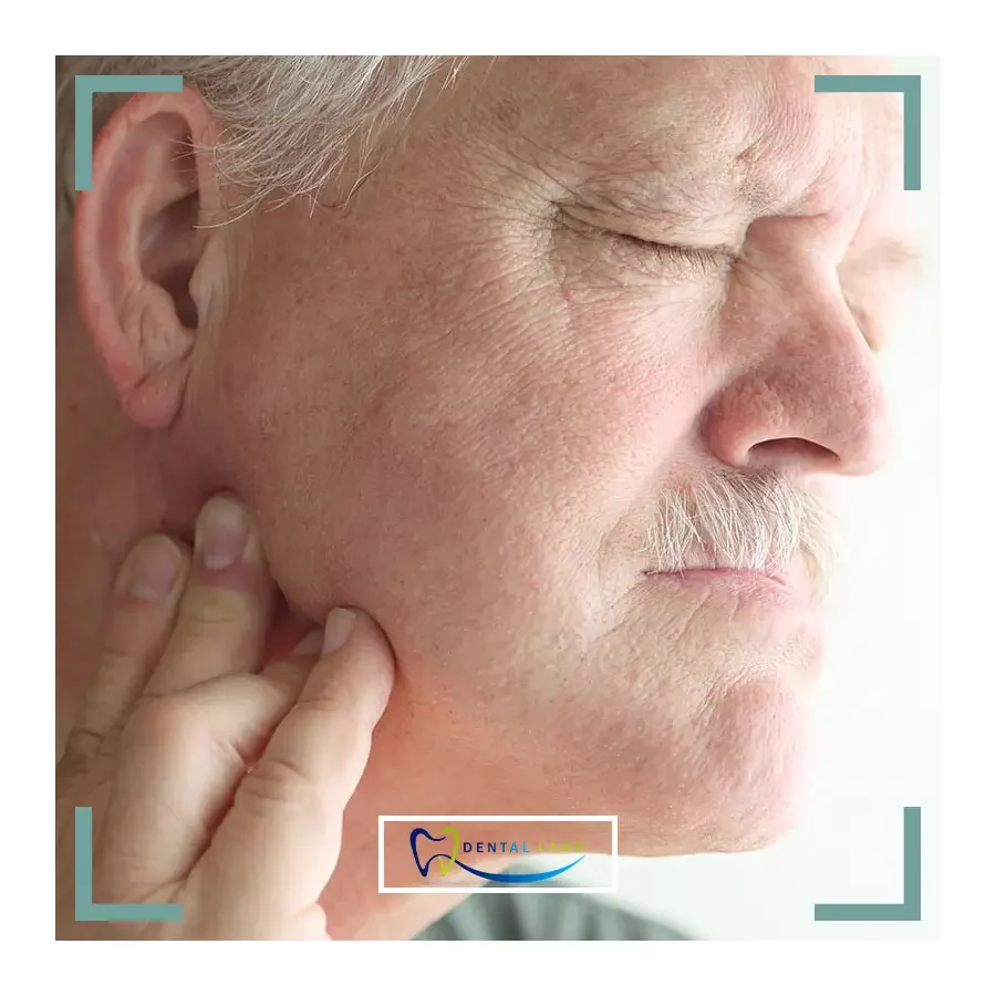 A man with Jaw pain holds his hand to his face, due to TMJ Disorders